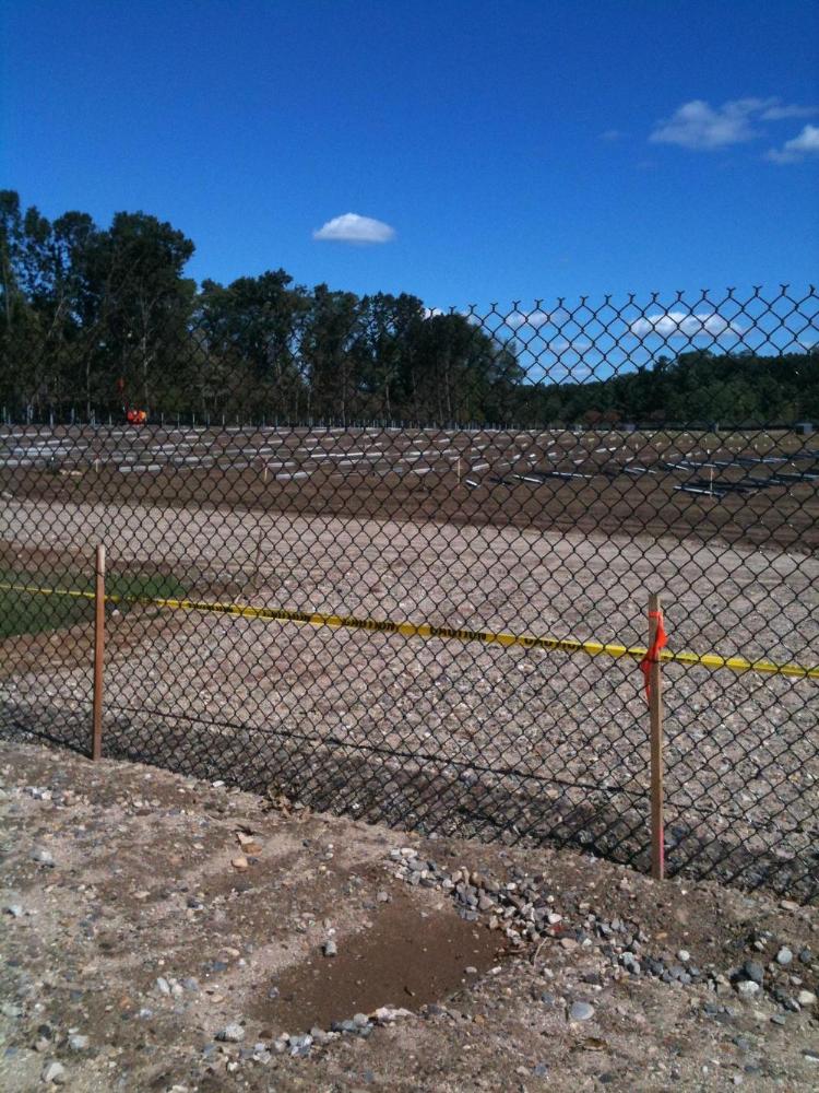 Solar panel construction through a fence at the Shoemaker Lane Solar Farm