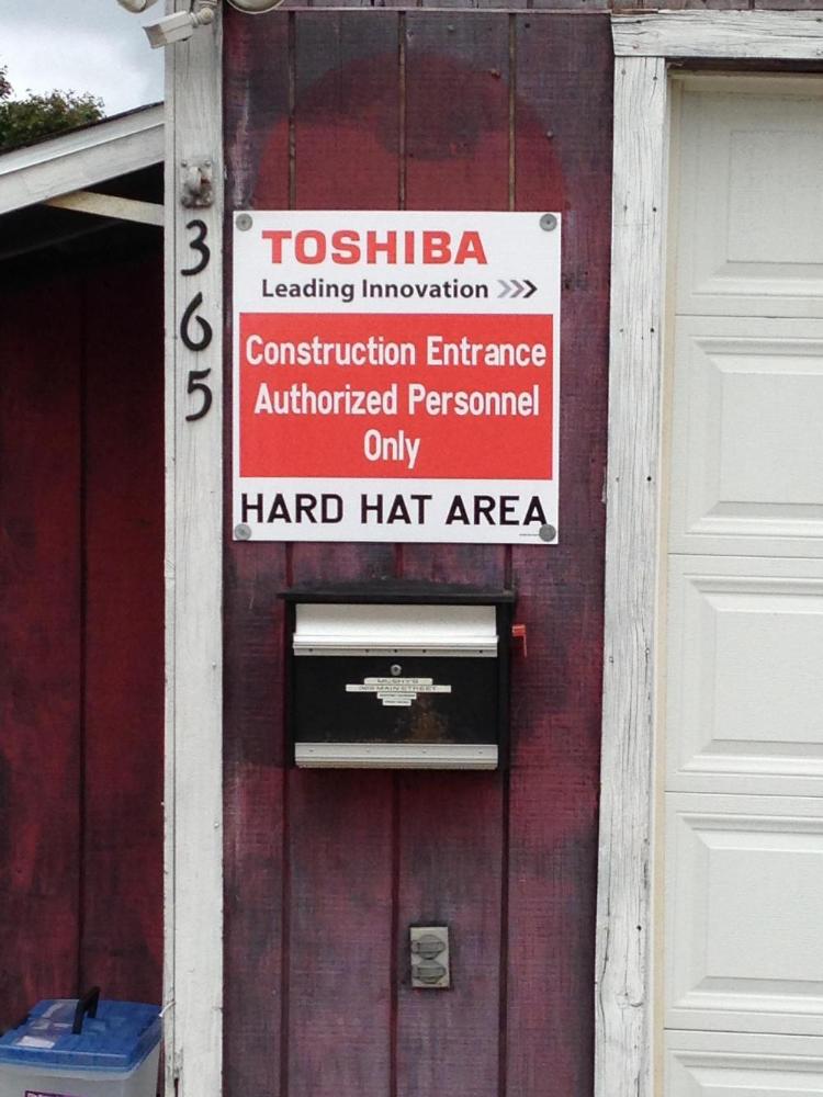 Toshiba leading innovation. Construction entrance. Authorized personnel only. Hard hat area.